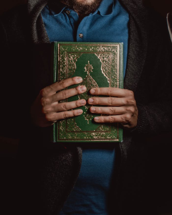 Photo Of Person Holding Religous Book 